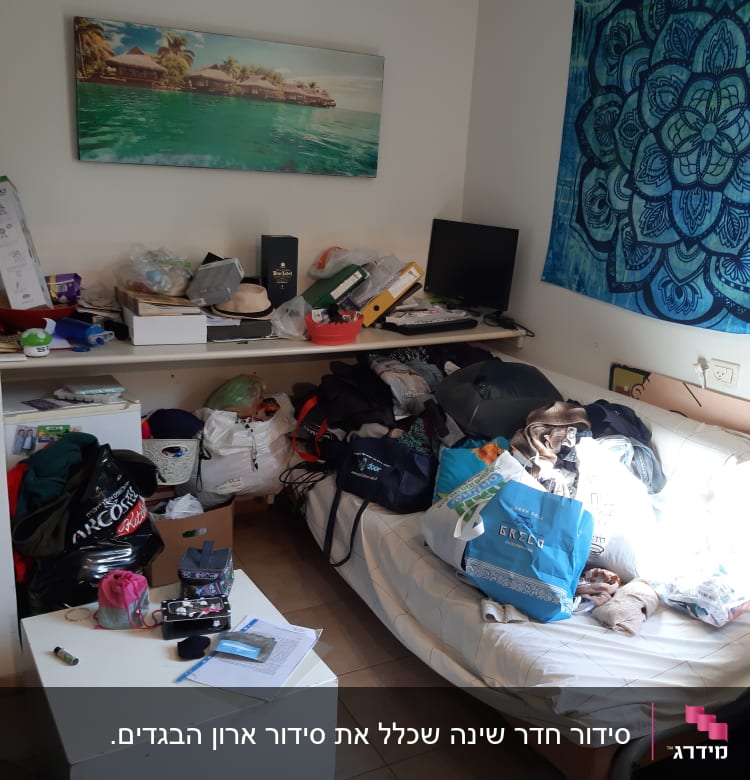 חדר מבולגן עם חפצים על המיטה והשולחן